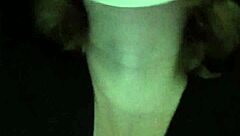 Petite girl gently caresses her natural big tits through black shirt and bra