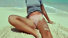 Blonde relaxes by the sea, showing off her curves in the sand