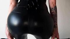 dominatrix in tight leggings demands ass worship from her slave, teasing with face sitting and juicy curves in this femdom fetish scene.