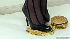 Japanese woman in stockings and heels crushes a hamburger under her feet in fetish food play